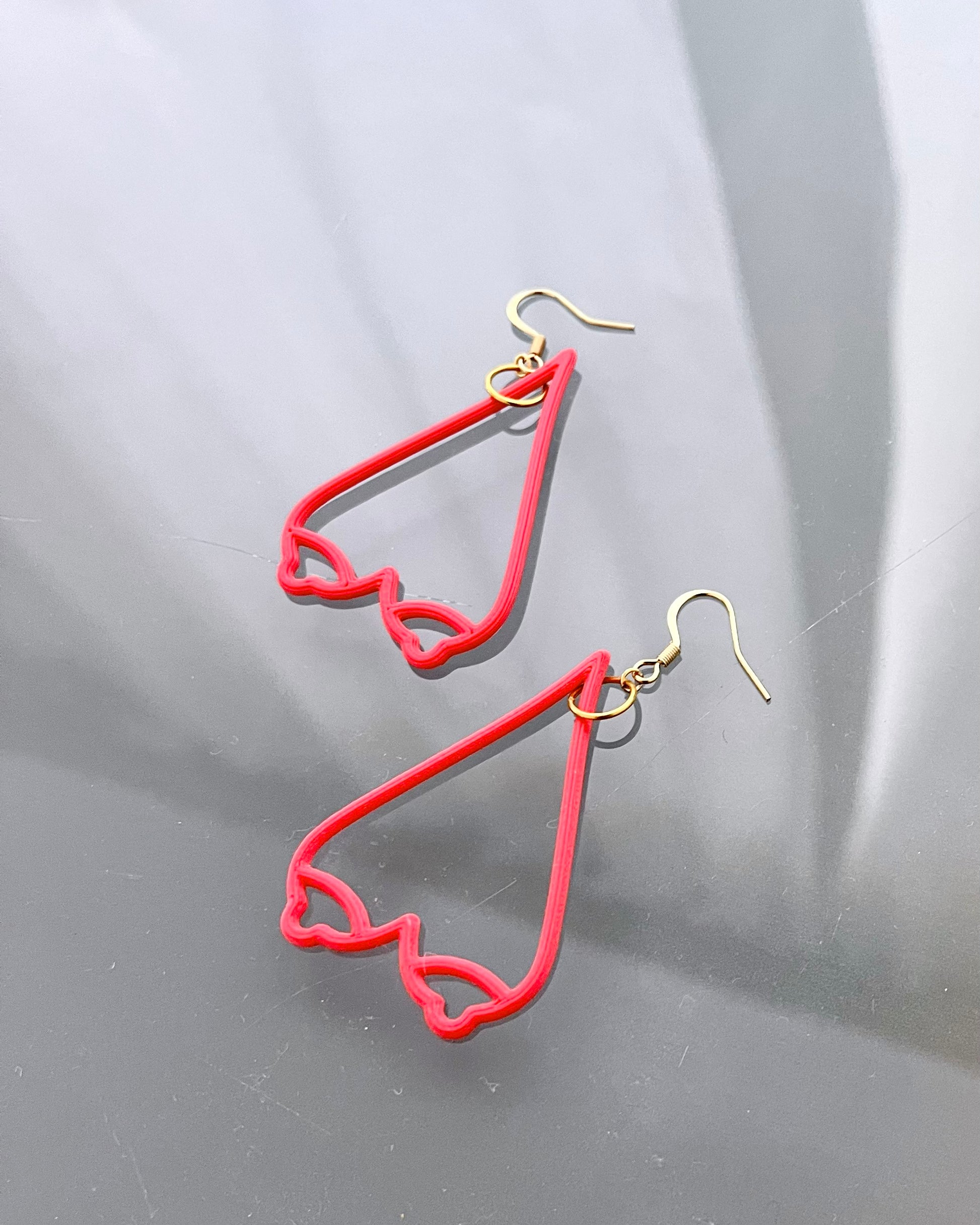 Red breast shaped earrings on a gray background