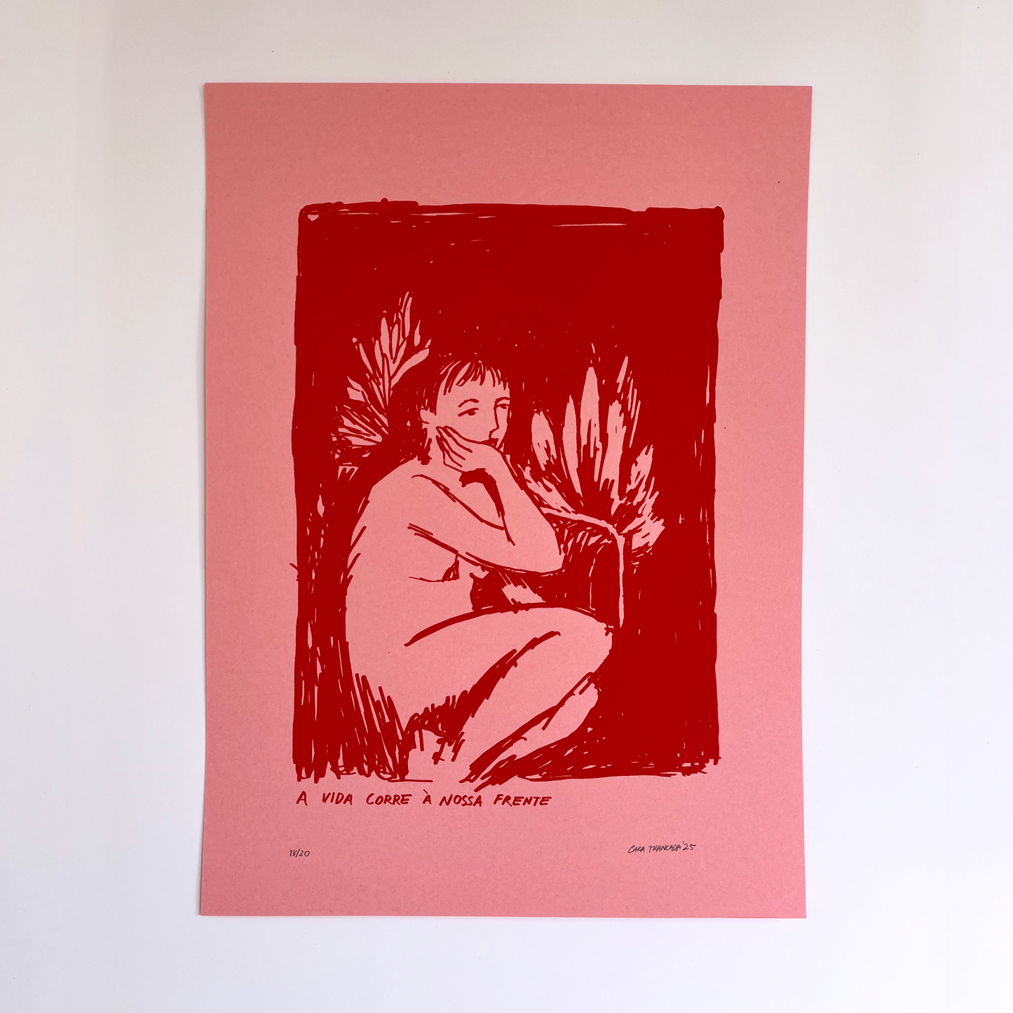 Red ink print of a nude figure with text on a pink background