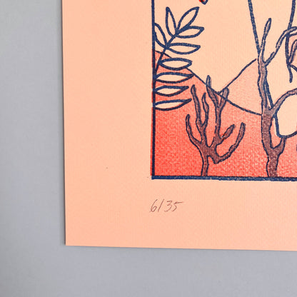 Art print with botanical design on a peach background, framed against a blue wall.